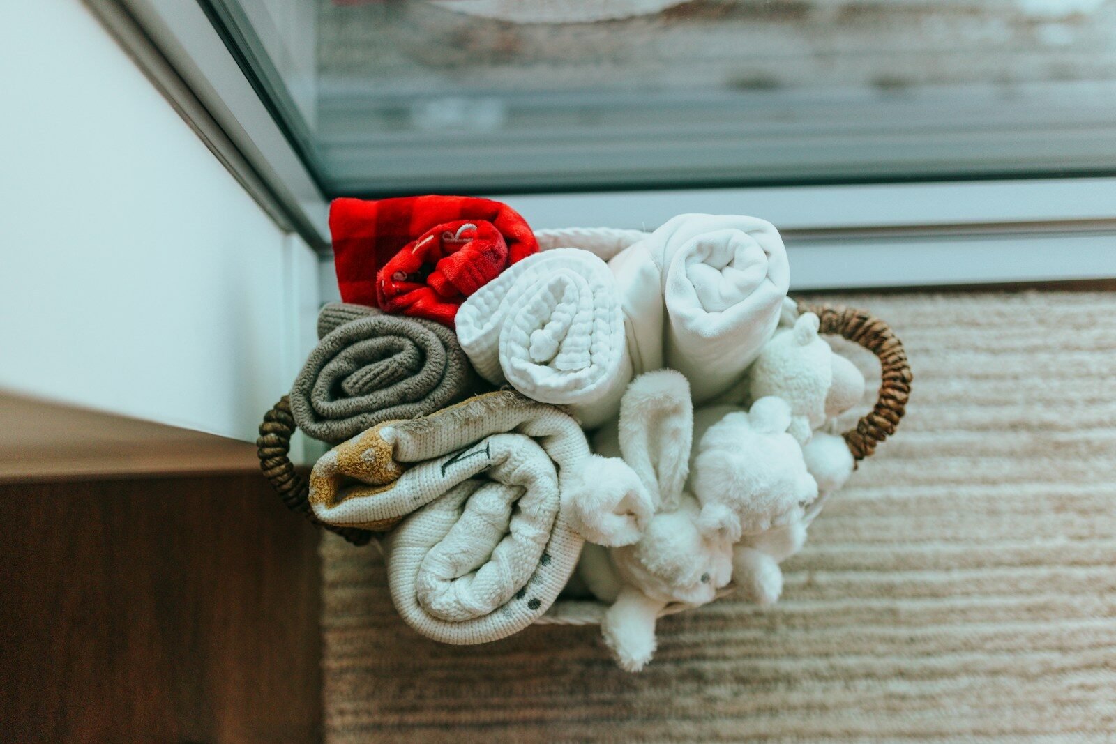 a basket filled with towels sitting on top of a wooden floor