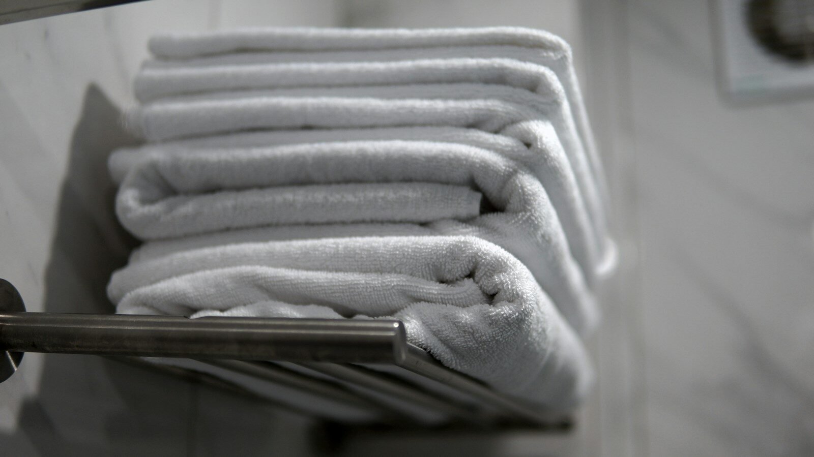 A stack of folded towels sitting on a towel rack