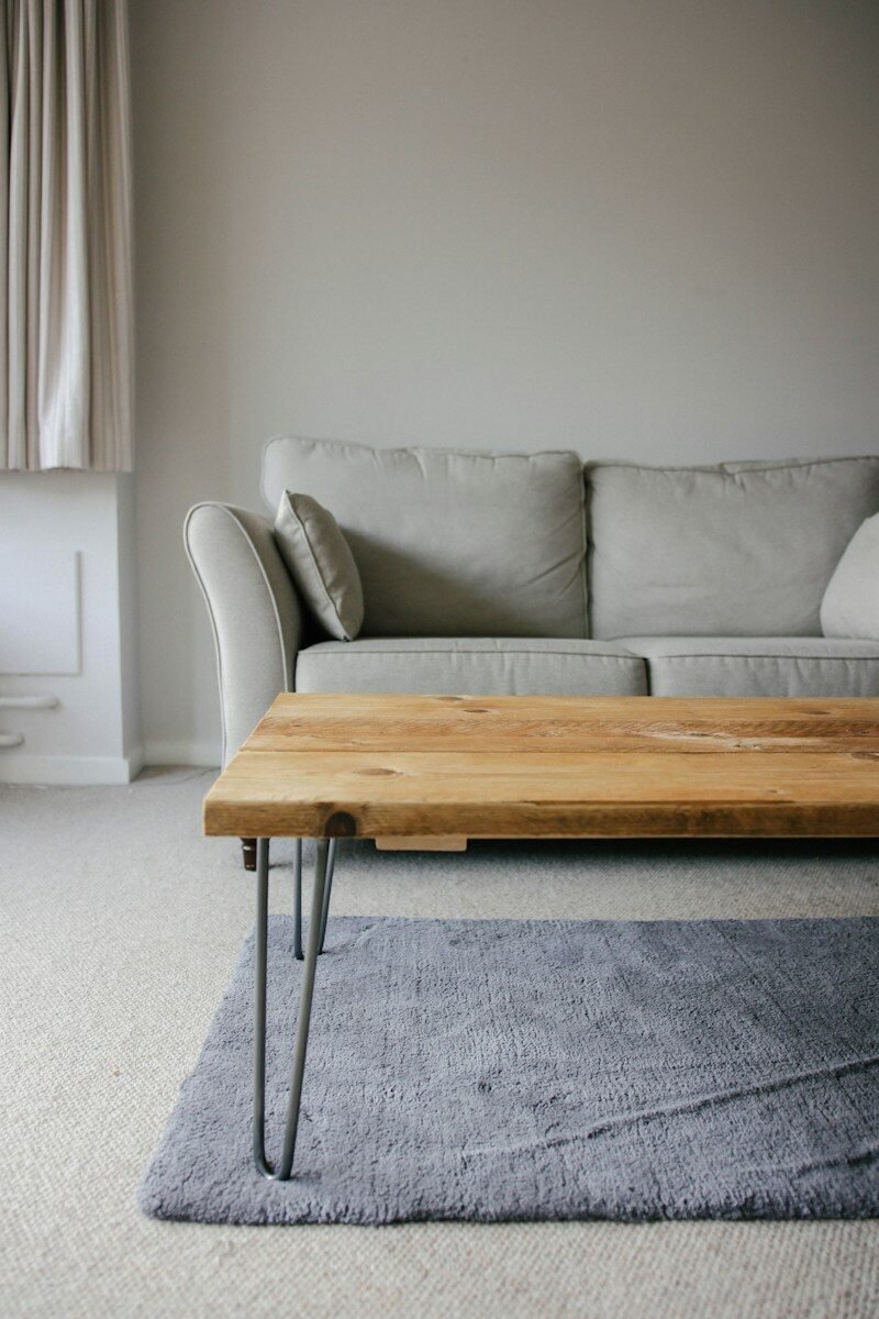 brown wooden table beside white couch