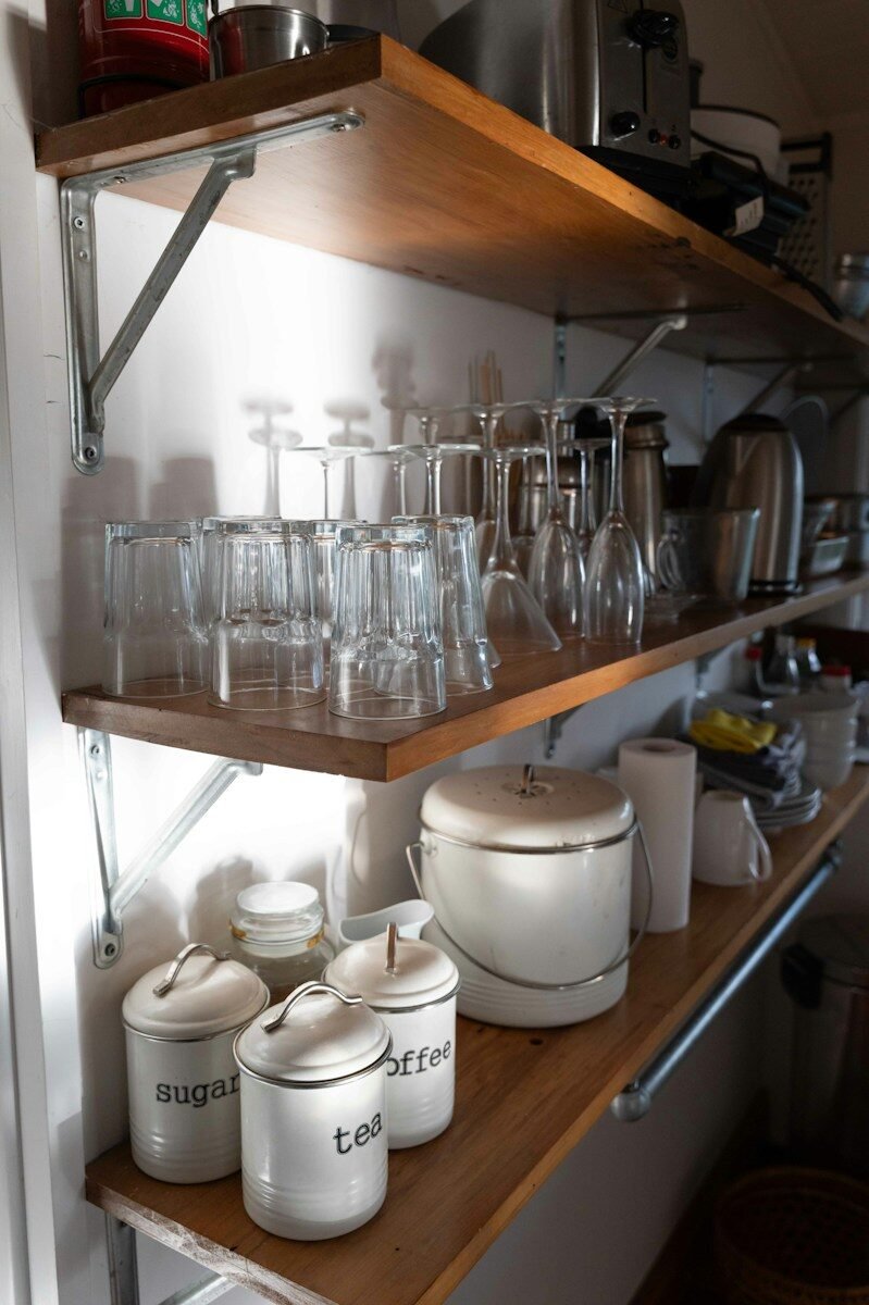 Kitchen shelves stocked with glasses, canisters, and appliances