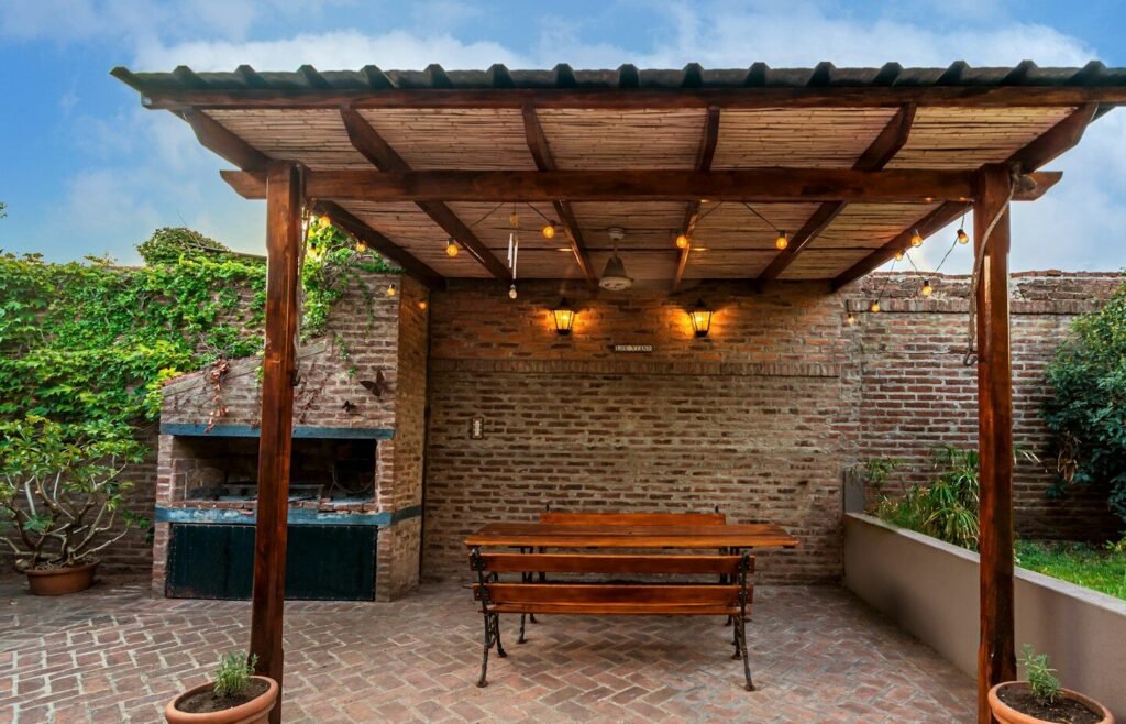 a wooden bench sitting under a wooden pergoline