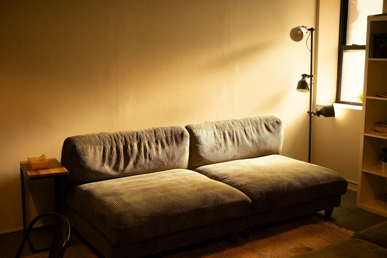 A comfortable sofa bathed in warm lamp light