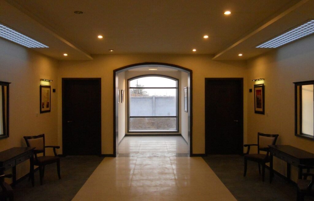 Hallway with doors, chairs, and arched window