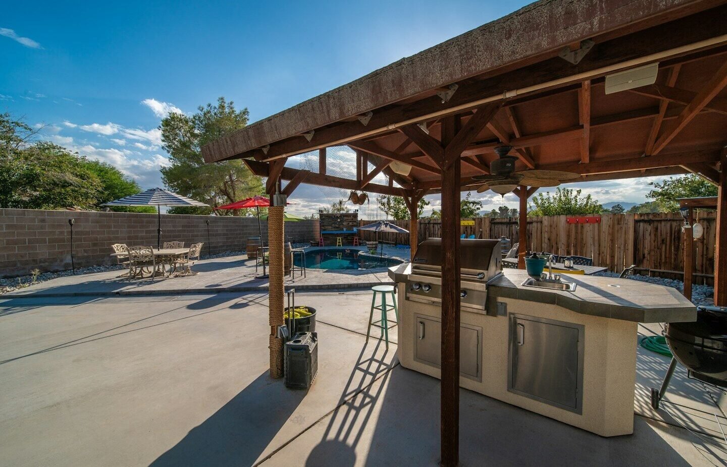 a covered patio with a grill and a table