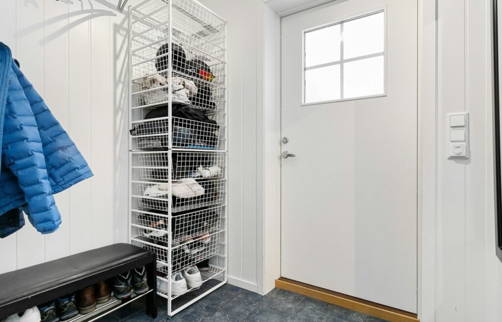 A walk in closet with a coat rack and shoes